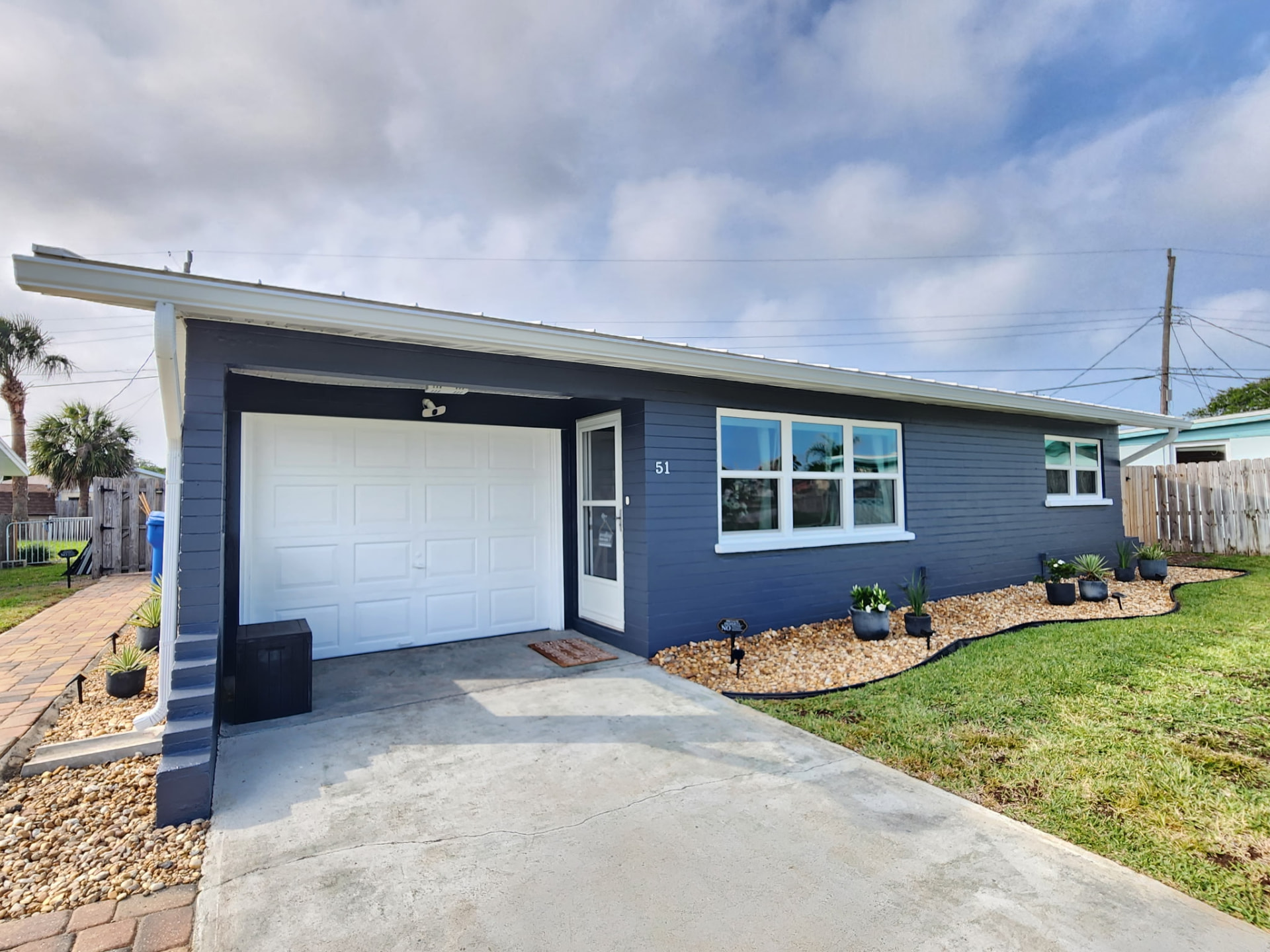 Navy blue house with white garage door, windows and trim freshly painted