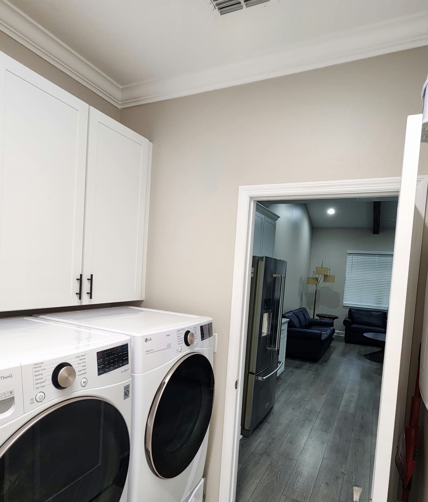 Laundry room with white cabinets, greige walls and fresh white door trim