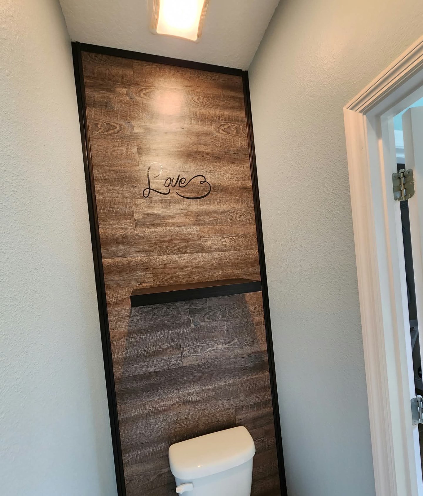 Half bath with wood plank accent wall and light blue painted walls