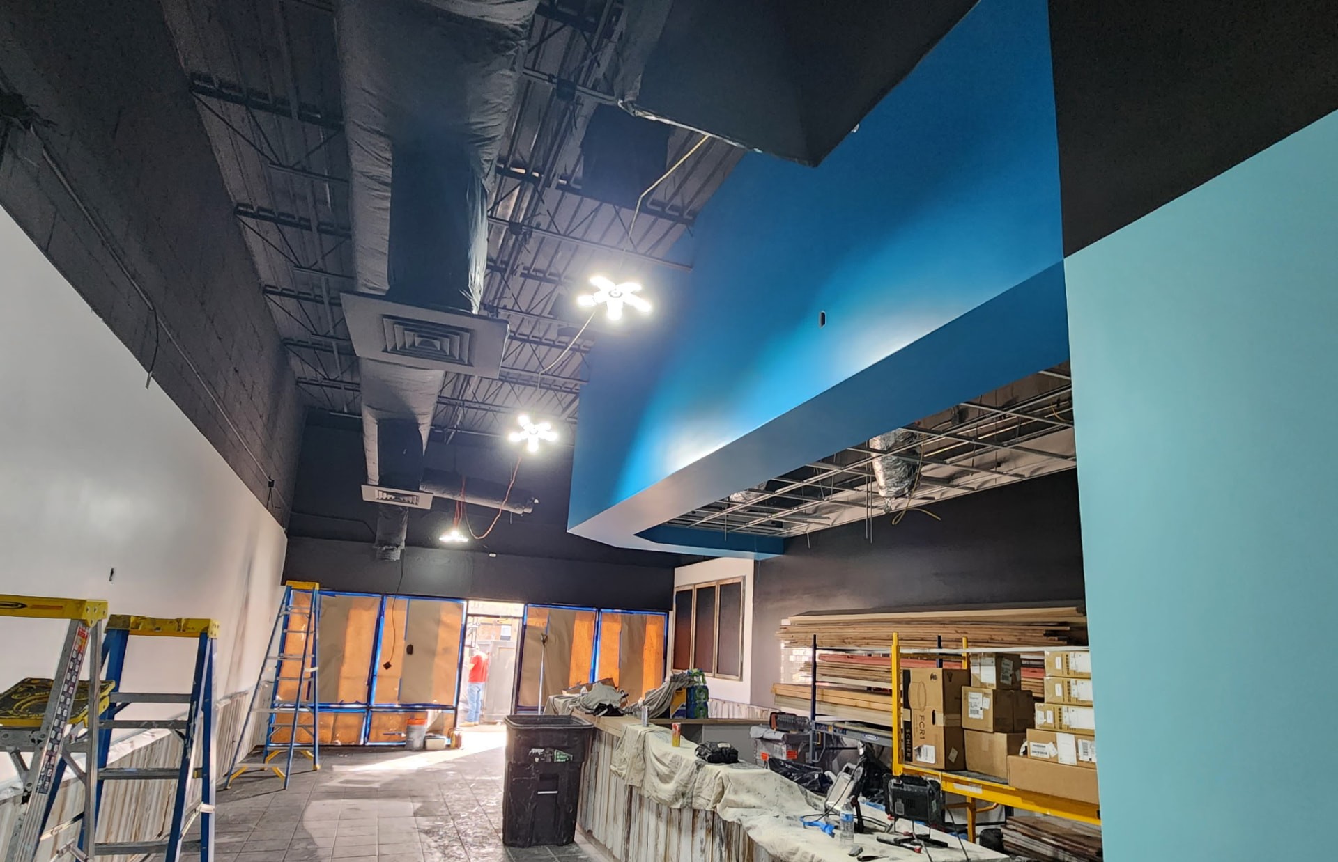 Commercial interior under renovation with a wood-wrapped service counter and fresh paint