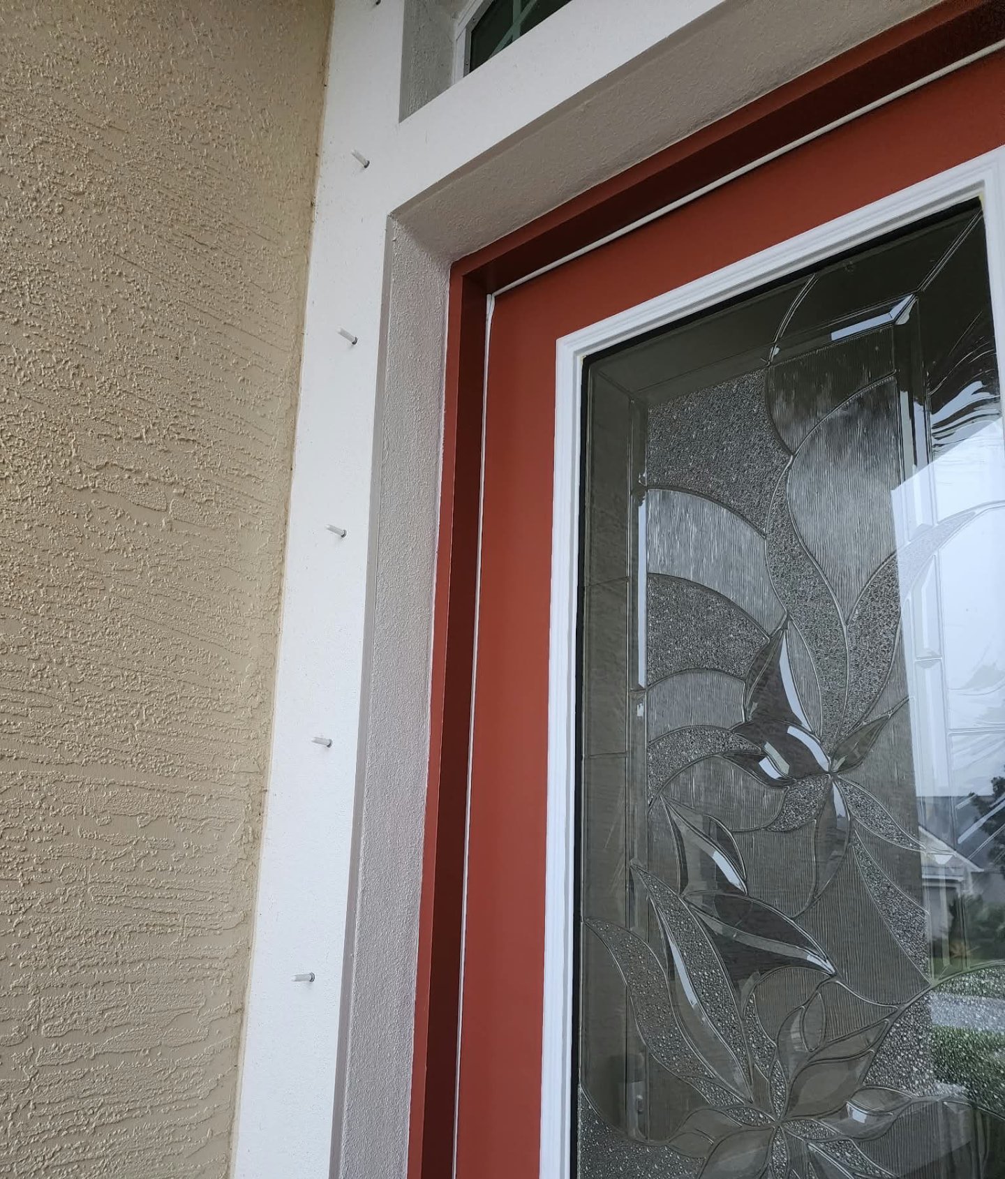 Front door repainted deep red with clean white trim and stucco